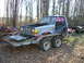 1985 Ford Bronco - Silver Ford Ranger pickup truck on a trailer, hood open, in a wooded area.