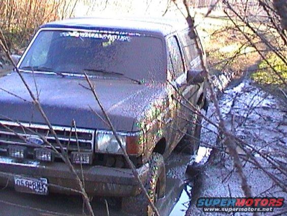 Mud-covered 1989 Ford Bronco navigating a muddy trail