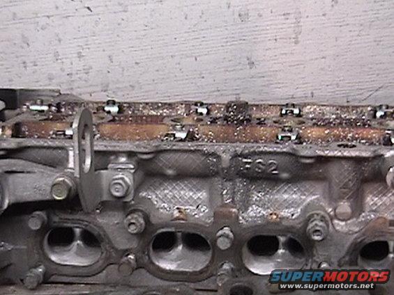 Close-up of an engine cylinder head with visible ports and some markings