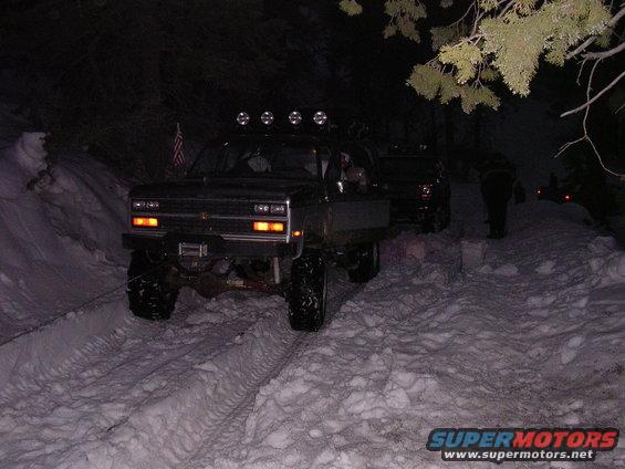 Truck with lifted suspension and off-road tires in snow, front view