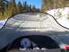 1994 Ford Bronco - View from a snowmobile dashboard as it travels down a groomed, snowy trail in a forest.