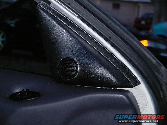 Close-up of a car's A-pillar trim with a speaker grille and a door lock switch
