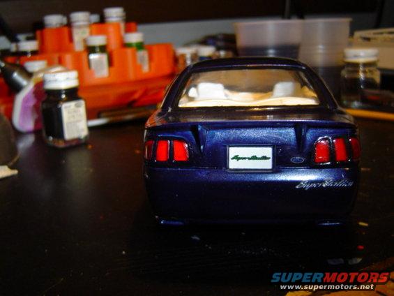 Model car's rear end, blue with red taillights and a white plate that says 'Super Stallion'