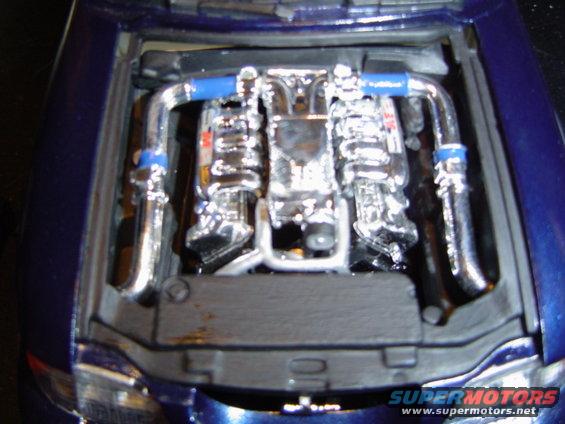 Model engine bay with chrome V8 engine and blue hoses