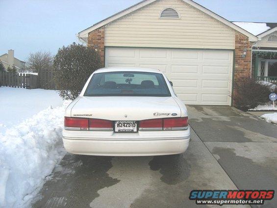 White 1997 Ford Crown Victoria parked in driveway, rear view, snow on the ground