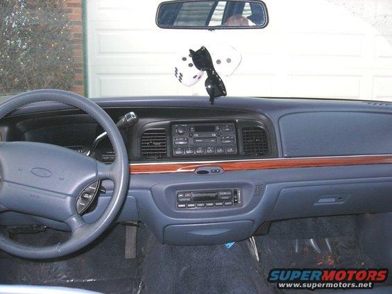 1997 Ford Crown Victoria interior dashboard with wood trim, dice, and sunglasses hanging from mirror
