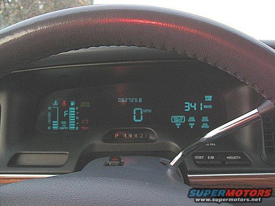 Dashboard of a 1997 Ford Crown Victoria showing digital gauges, odometer reading 082123.8, and gear selector