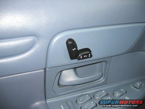 Power seat controls on a light blue interior door panel with a door handle and window controls