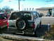 1996 Ford Bronco - Rear view of a white Ford Bronco with a spare tire mounted on the back, parked outdoors.