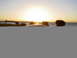 2003 Ford Taurus - A car's roof is visible in the foreground with a sunset over the water in the background.