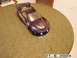 1998 Mercury Sable - A purple Pontiac Firebird Trans Am model car body with flame decals sits on a textured round table.
