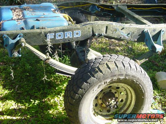 Ford chassis with leaf springs and a tire, blue fuel tank visible