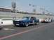 1965 Ford Mustang - A blue 1965 Ford Mustang race car with white stripes and the number 2 is on the track, with other cars in the background.
