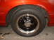 1999 Ford Crown Victoria - Close-up of a wheel and fender on an orange vehicle.