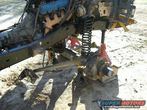 Vehicle chassis on jack stands with engine and front suspension visible