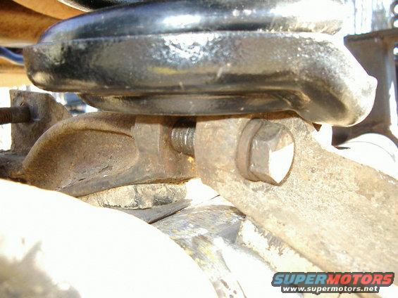 Rusty metal bracket with bolt and spring assembly