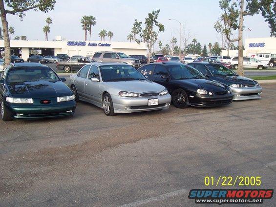 Dark green sedan parked in front of Sears Auto Center, front view