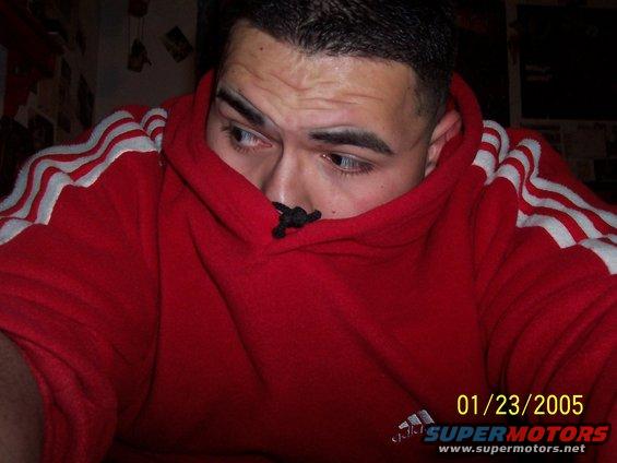 Man peeking out from a red hoodie with white stripes on the sleeves. Date stamp reads 01/23/2005