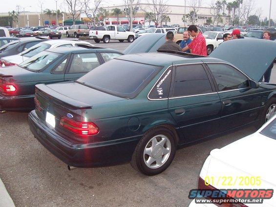 Green sedan with a spoiler and sunroof, parked in a lot
