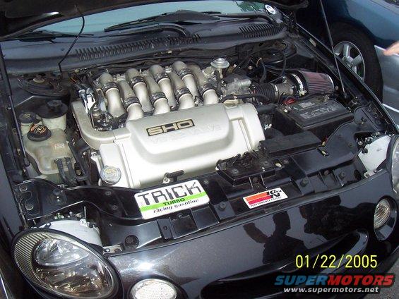 Black 1998 Mercury Sable engine bay with SHO V8 engine, K&N filter, and 'Trick Turbo' sticker
