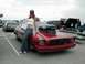 1978 Ford Mustang II - A woman poses with a modified red drag car a prominent hood scoop and custom grille.