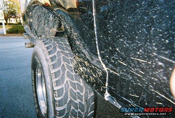 Black SUV side view, covered in mud splatter and scratches, with a Yokohama tire visible