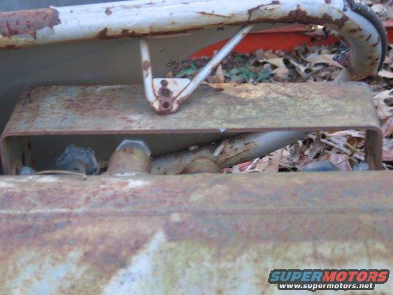 rusted metal frame and pipes, some leaves on the ground