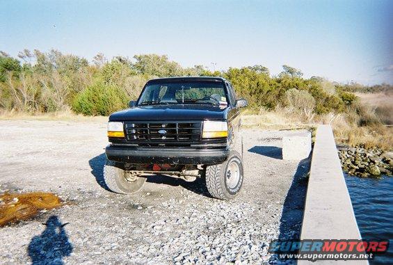 Black 1996 Ford Bronco parked on gravel near water