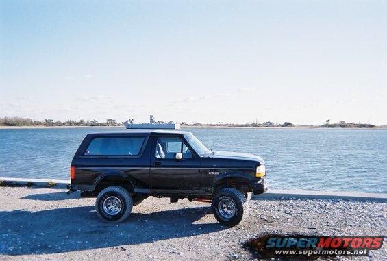 Black Ford Bronco parked by the water