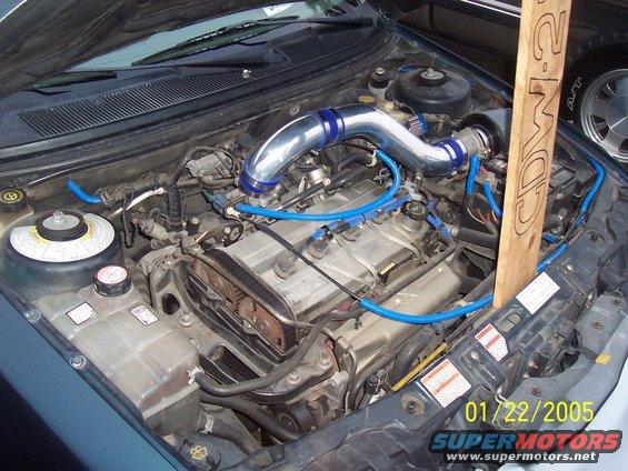 Engine bay of a 1998 Mercury Sable with aftermarket intake and blue hoses