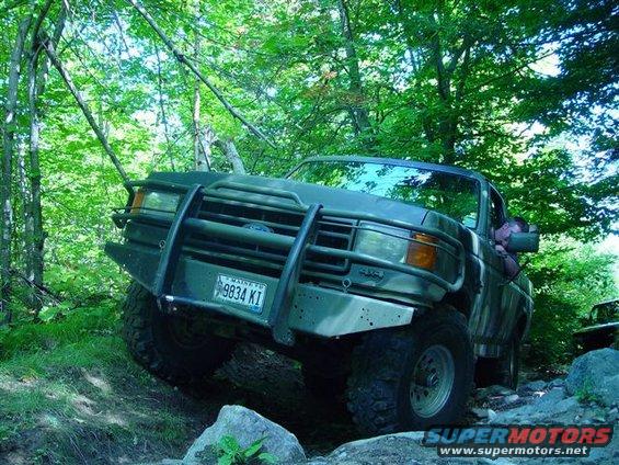 1996 Ford Bronco navigating a rocky, wooded trail