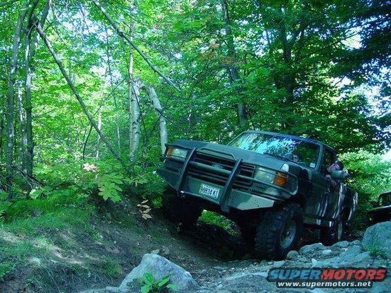Ford F-Series truck with bull bar driving on rocky trail