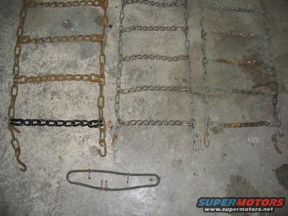 Three ladder-style tire chains and a metal tensioning tool on a concrete floor