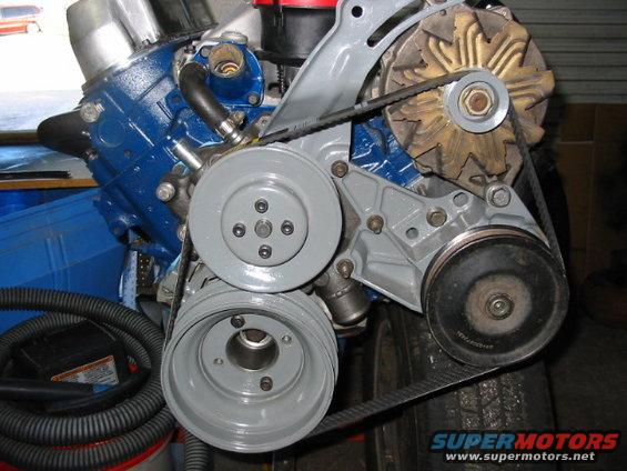 Close-up of engine pulleys and belts, with blue painted engine block visible