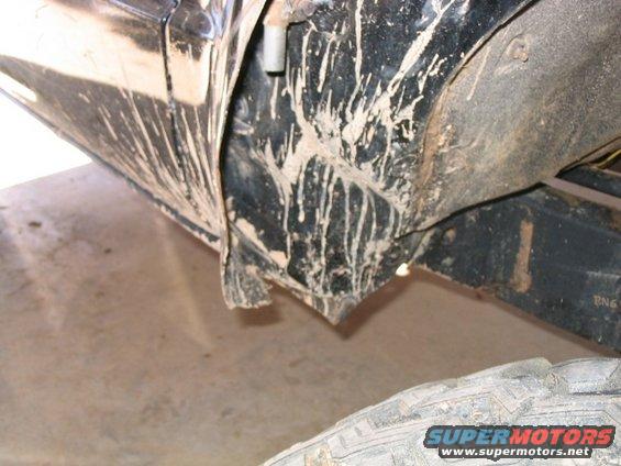 Mud splatters on black truck fender and frame, tire visible below