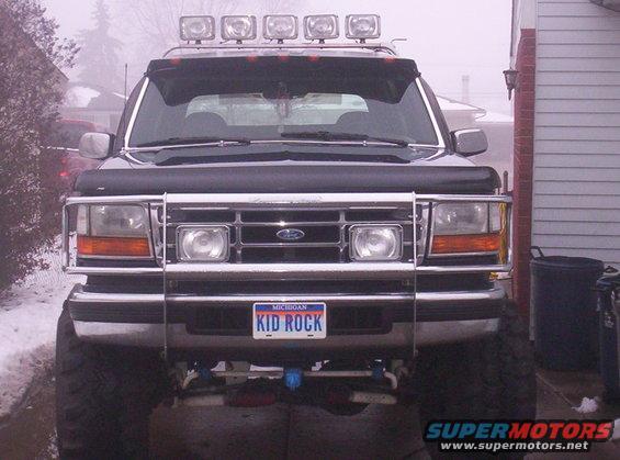 Front view of a black 1993 Ford Bronco with a light bar and brush guard