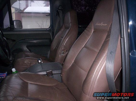 Brown leather bucket seats and center console of a truck, with 'Eddie Bauer' stitched on the headrest