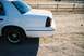 2000 Ford Crown Victoria - Rear view of a white 2000 Ford Crown Victoria parked on a dirt lot.