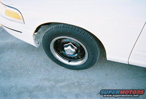Front wheel and fender of a white 2000 Ford Crown Victoria