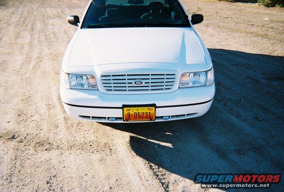 White 2000 Ford Crown Victoria front view, parked on dirt road