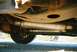 2000 Ford Crown Victoria - The underside of a vehicle reveals its exhaust system, including two mufflers and suspension parts.