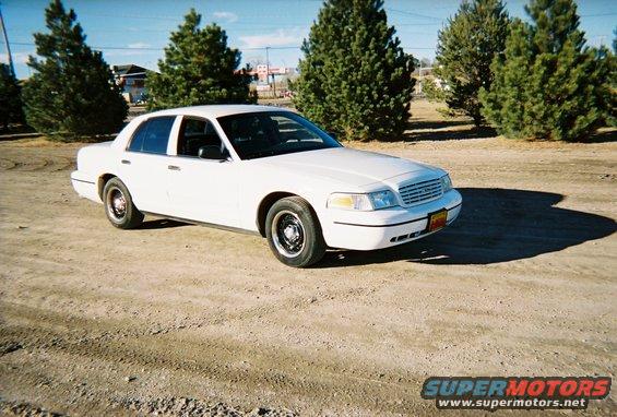 White 2000 Ford Crown Victoria parked on a dirt lot