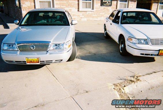 Silver sedan front view with 'POWER 99' license plate. White sedan to the right