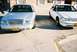 2000 Ford Crown Victoria - Two sedans are parked side-by-side, with the silver sedan in the foreground showing a 'POWER 99' license plate.