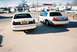2000 Ford Crown Victoria - Two Ford Crown Victorias are parked side-by-side on a sunny day.