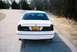 2000 Ford Crown Victoria - A white 2000 Ford Crown Victoria is parked on a road with a person standing behind it.