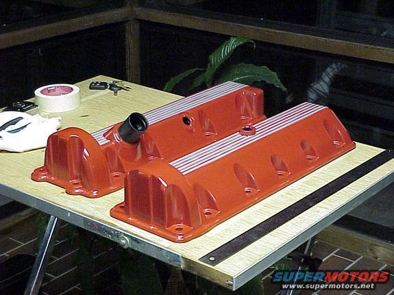 Pair of orange valve covers with silver stripes on a table