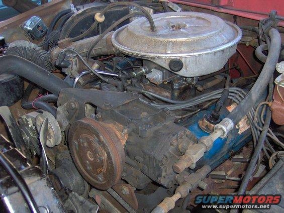 Engine bay with air cleaner, compressor, and hoses visible