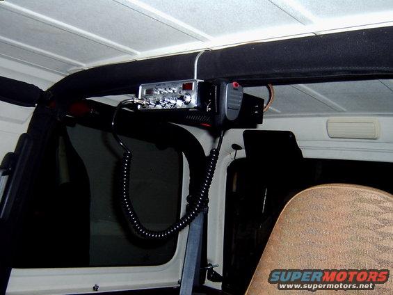 CB radio and microphone mounted above the driver's side window of a Jeep