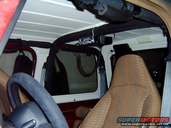 Interior shot of a Jeep showing the steering wheel, passenger seat, and a CB radio mounted overhead